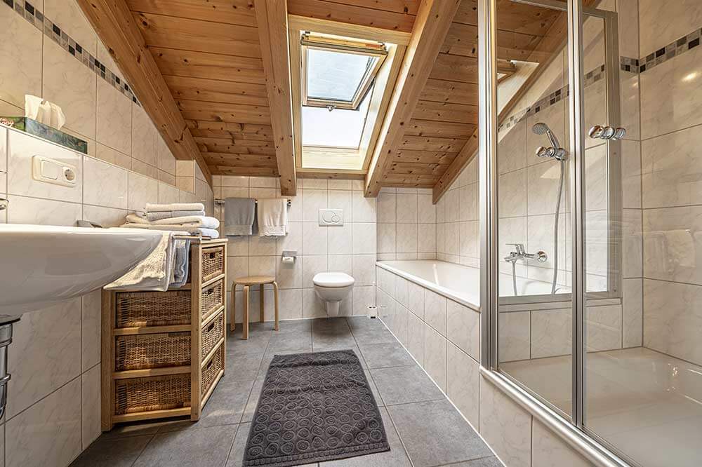 Badezimmer mit Dusche, Badewanne und WC der Ferienwohnung Hirsch